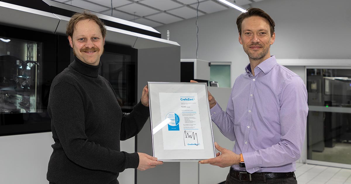 Alexander Staß (rechts) überreicht Geschäftsführer Holger Kern (links) das Bonitätszertifikat CrefoZert.